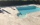 Vue d’ensemble d’une piscine et de sa plage dallée en pierre calcaire