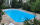 Piscine extérieure entourée de dalles beiges nuancées