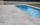 Terrasse extérieure en dalles travertin autour de la piscine