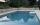 Piscine extérieure entourée de plage et margelle en pierre naturelle